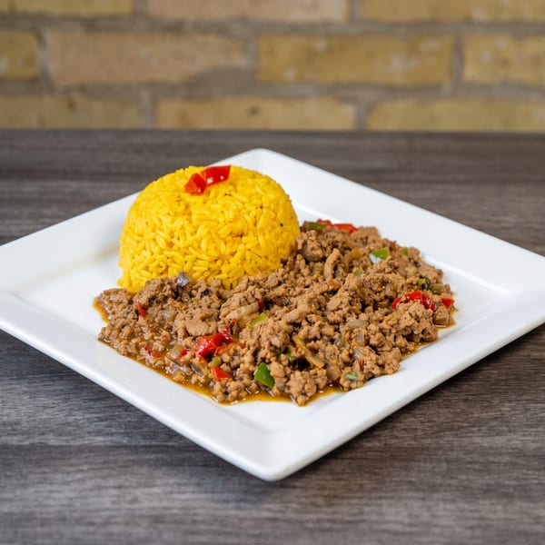 A white rectangular plate holds yellow rice and seasoned ground meat with peppers and onions.
