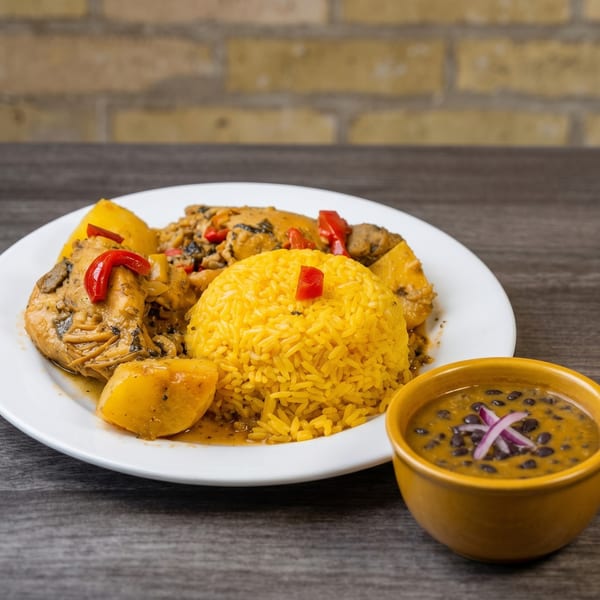 Chicken and potatoes in sauce with yellow rice, and a side of black bean soup.